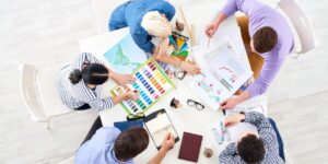 Équipe réunie autour d'un tableau blanc dans une dynamique de travail collaboratif